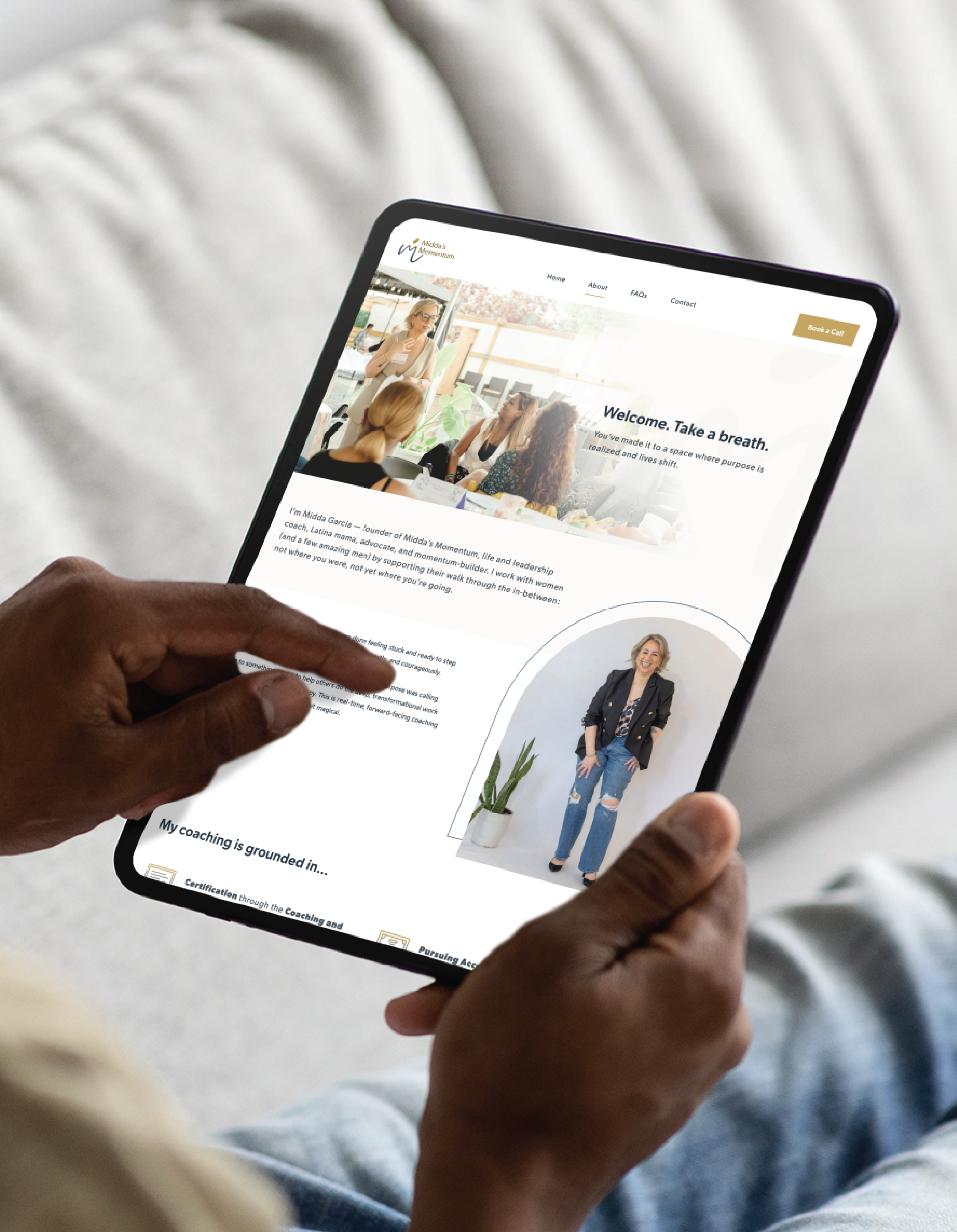 A person holding a tablet and browsing a website featuring a welcome message, an image of a smiling woman with flowers, and branding elements that highlight educational consultants, plus another woman standing and smiling in casual attire.