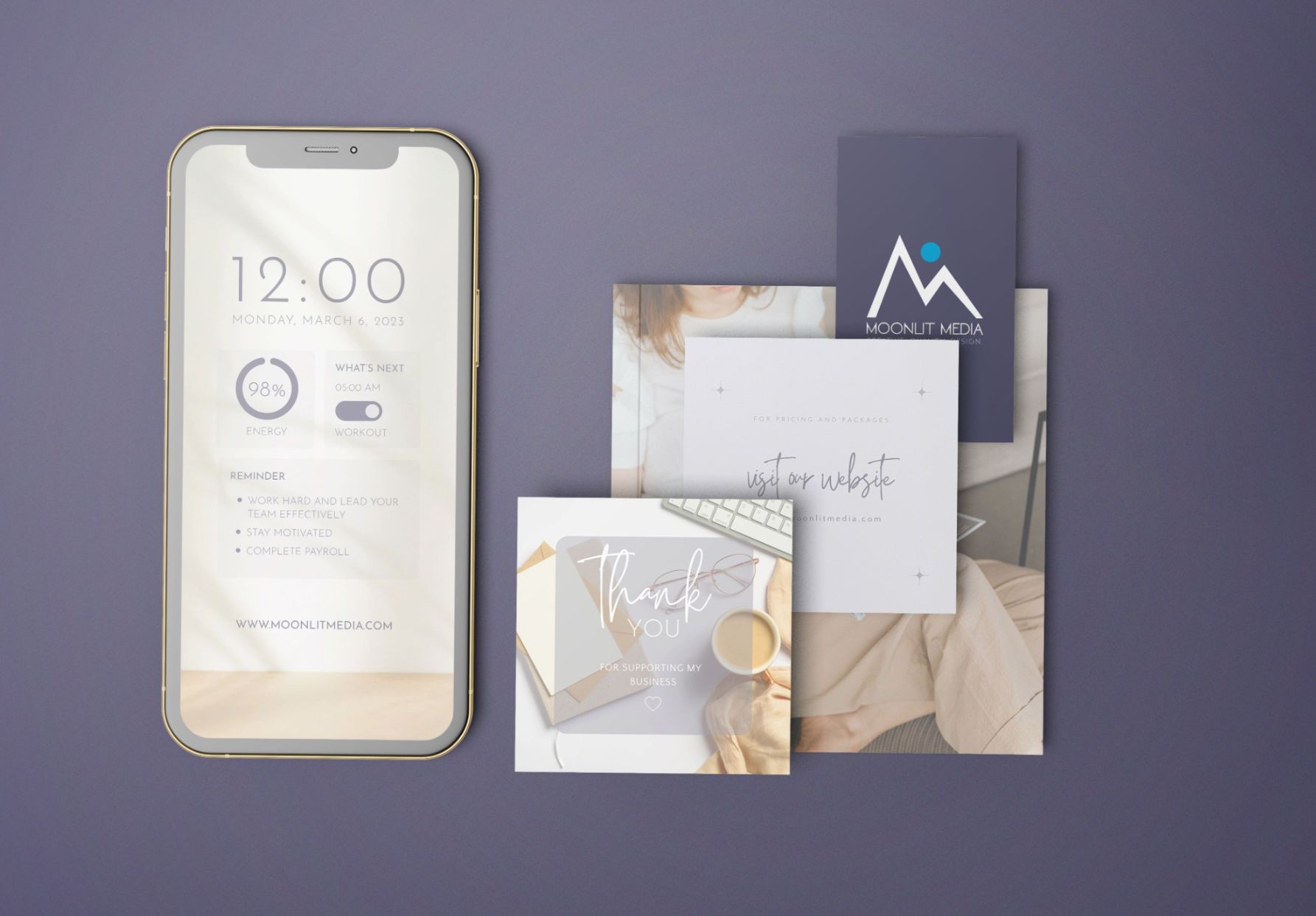 A smartphone displaying a minimalist calendar screen sits beside assorted business cards and thank you notes on a purple surface, with one card showcasing the Moonlit Media logo—highlighting their expertise in custom website design.