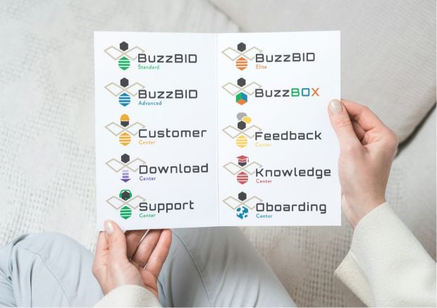 A person holds a paper displaying various colorful logos, mascots, and names for unique brands such as BuzzBID, BuzzBOX, Customer Center, Feedback Center, Download Center, Knowledge Center, Support Center, and Onboarding Center.