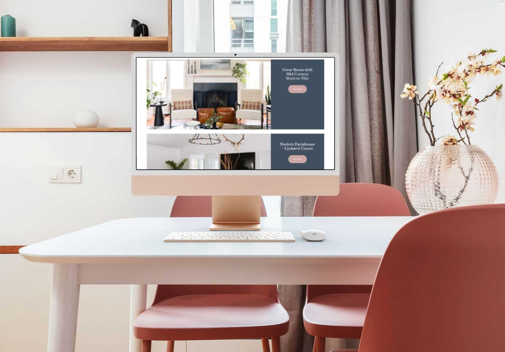 A desktop computer on a white desk displays a home decor website by a talented web designer in a bright room with pink chairs, shelves, and a vase with branches on the table.