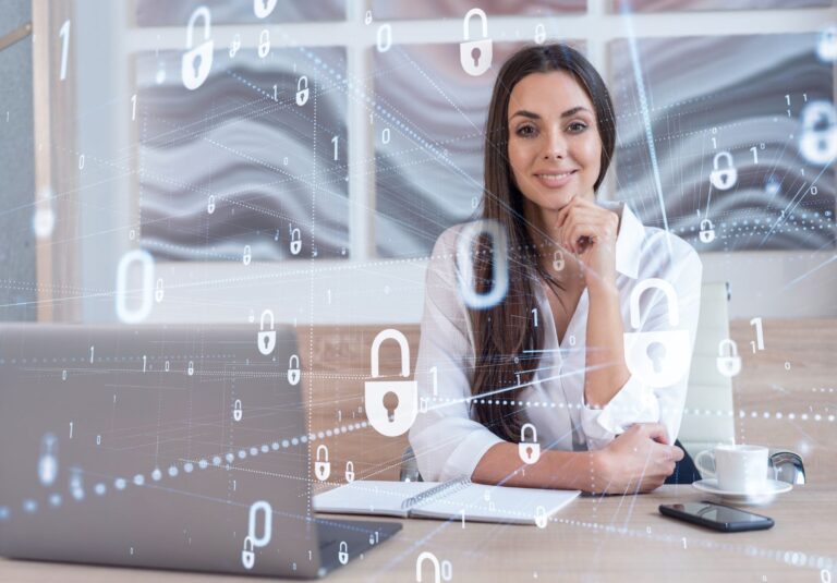 A woman sits at a desk with a laptop, notebook, and coffee cup, smiling at the camera. Digital padlock and binary code graphics overlay the image, reflecting moonlit media’s focus on cybersecurity and custom website design.
