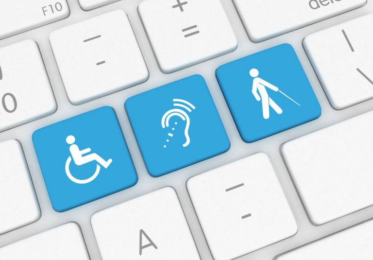 Three blue keyboard keys display white icons representing accessibility: a wheelchair user, an ear with sound waves for hearing impairment, and a person with a cane—highlighting the importance of inclusive web design services.