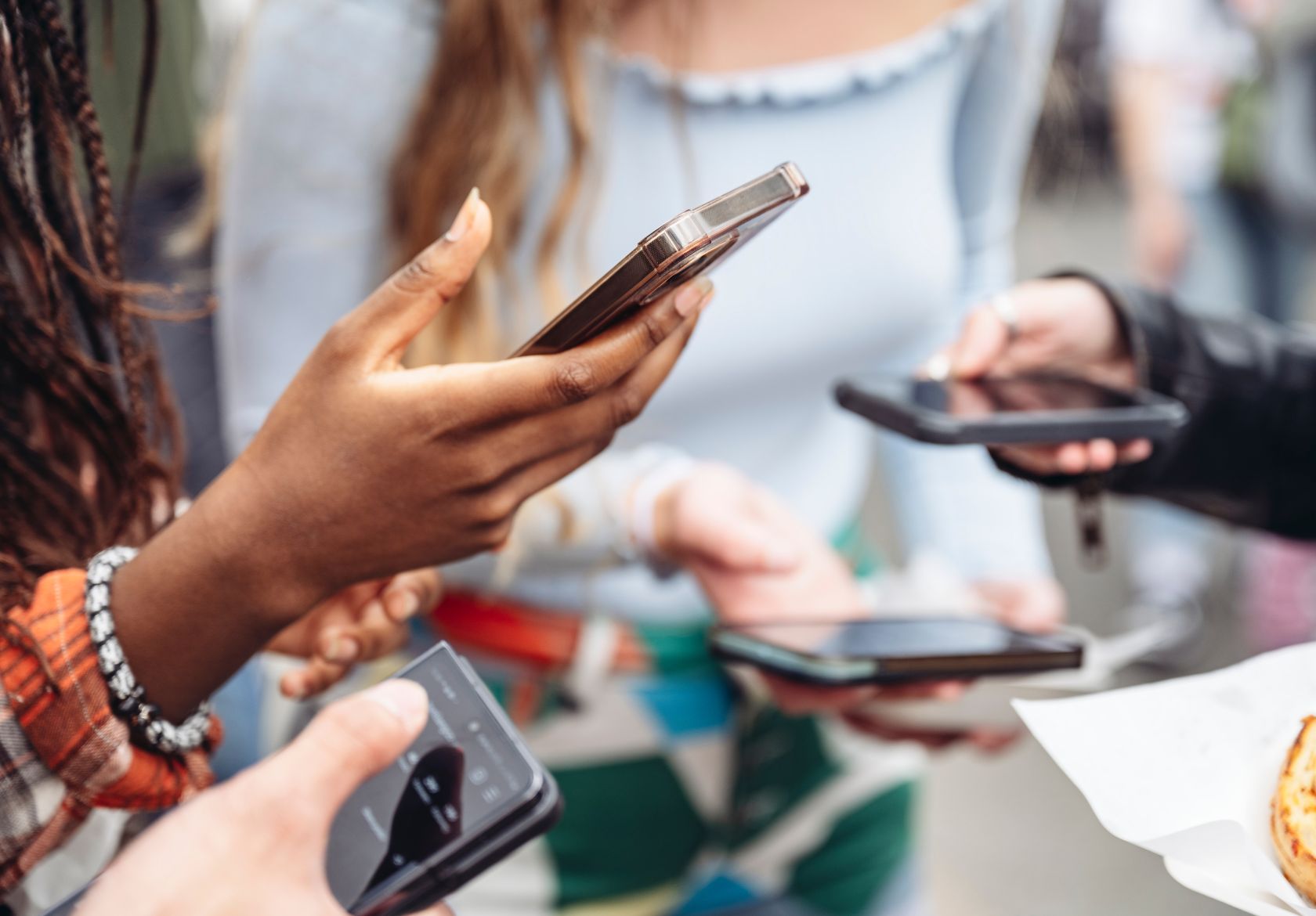 A lively gathering of individuals, each focused on their cell phones, highlighting the role of technology in social interactions.