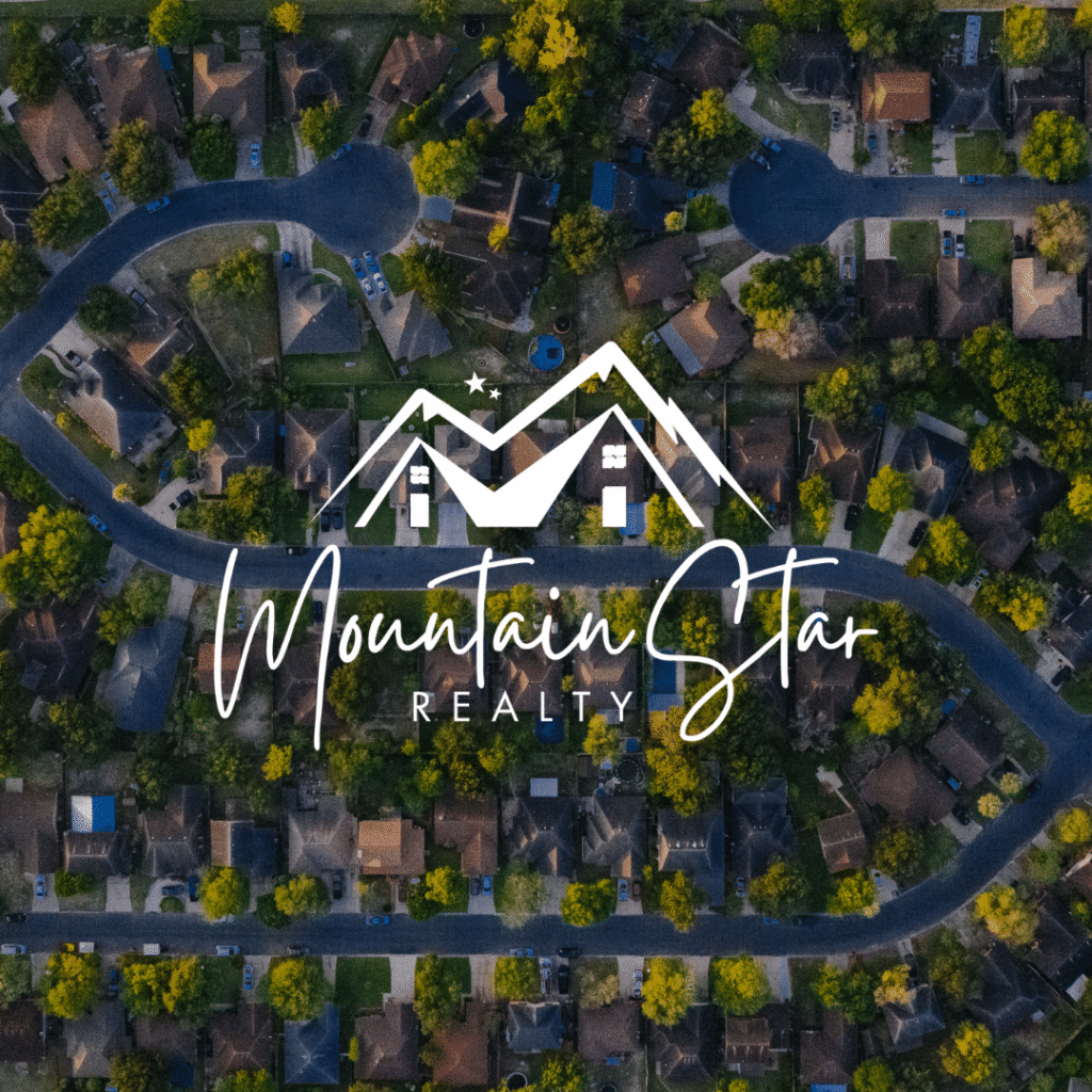 Aerial view of a suburban neighborhood with winding roads and houses surrounded by trees. The Mountain Star Realty logo, crafted with expert logo design services, is overlaid in the center, featuring mountain and house graphics.