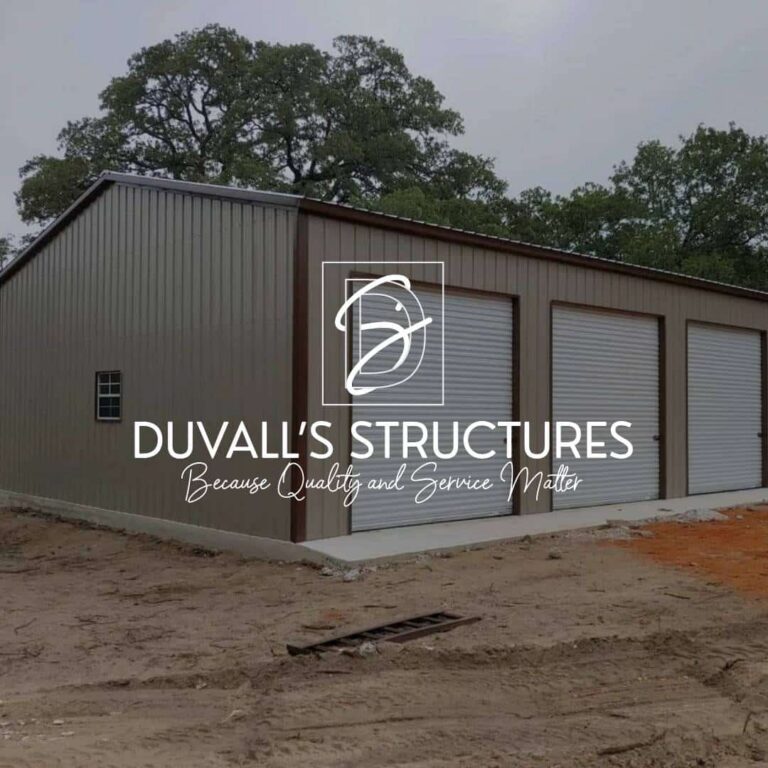 A large metal garage building with three white roll-up doors, surrounded by bare ground and trees. The text DUVALLS STRUCTURES - Because Quality and Service Matter is overlaid in the center, highlighting our custom website design and web design services.