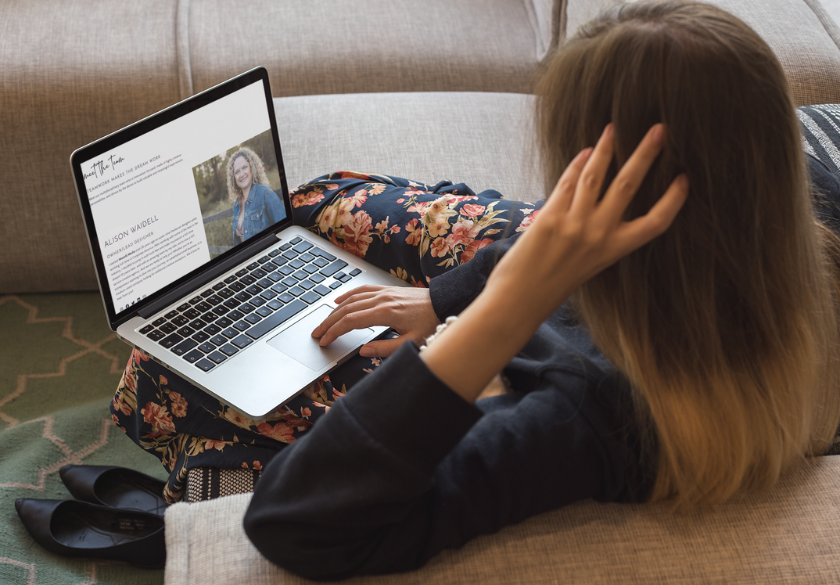 five second rule. A woman with long hair sits on a couch, using a laptop. The screen displays a profile page with clarity—a photo and text stand out. She rests her hand on her head, wearing floral-patterned pants, perhaps strategizing marketing in 2026.