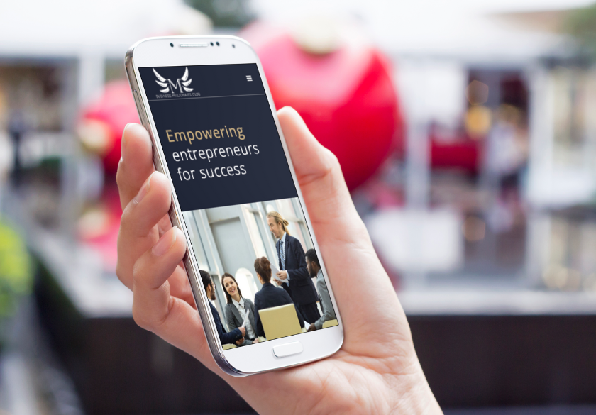 Simple ways to make your marketing clearer. A hand holds a smartphone displaying a website with the text Empowering entrepreneurs for success and an image of people in a business meeting, highlighting marketing clarity. The background is blurred with red shapes.
