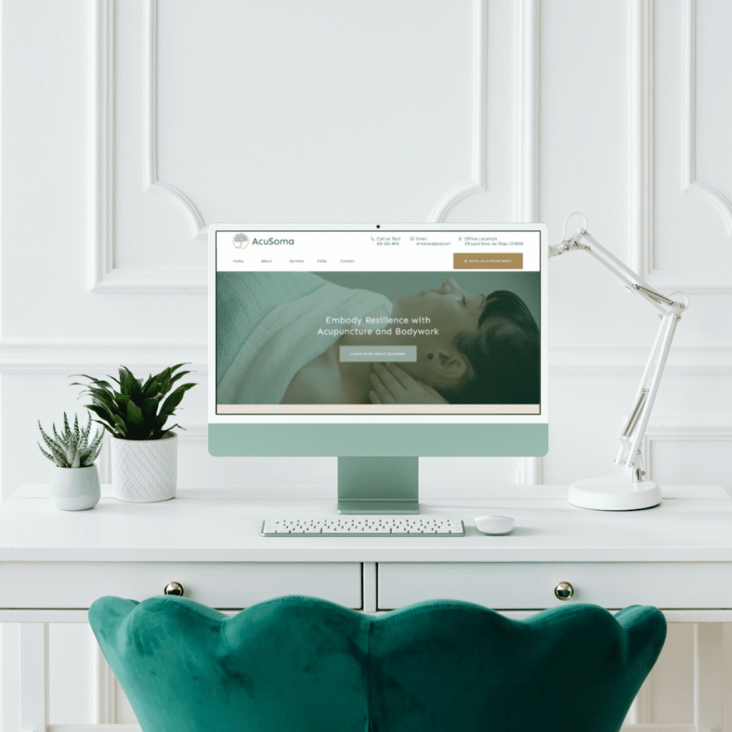 A stylish workspace with a green velvet chair, white desk, potted plants, and a computer displaying Moonlit Media—a web designer’s wellness website featuring custom logo design and a person receiving a massage.