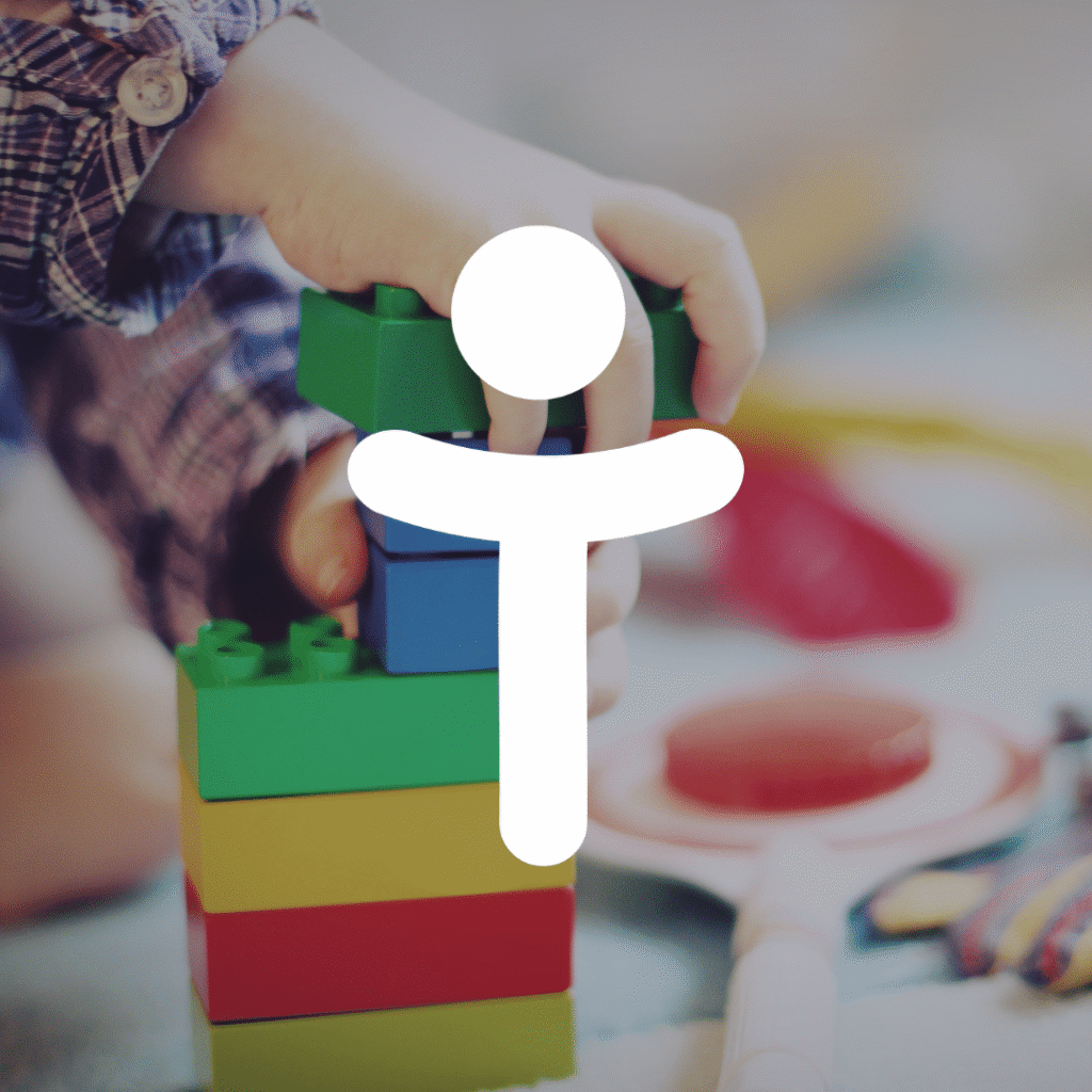 A child’s hand stacking colorful toy building blocks, with a white abstract icon of a person overlaid in the center, symbolizing creativity and custom website design.
