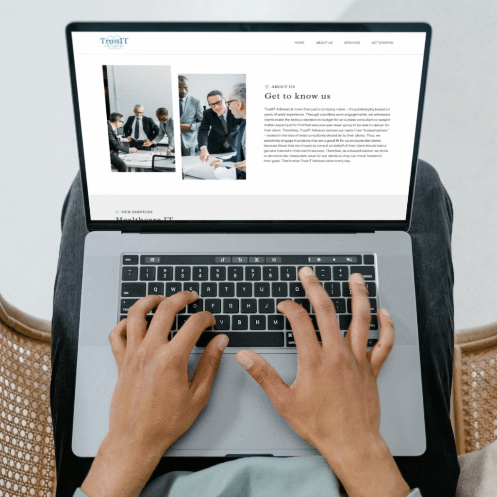 A person types on a laptop displaying a business website with a section titled Get to know us, featuring images of professionals in a meeting—highlighting the value of custom website design.