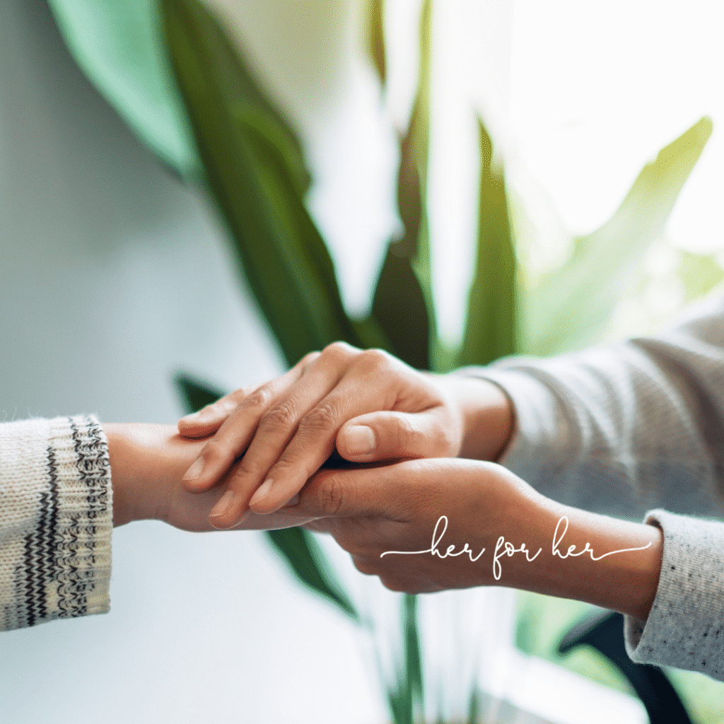 Two people gently holding hands in a comforting gesture, with green plants in the background. The words her for her appear in cursive at the bottom, reflecting Moonlit Media’s touch for custom logo design.