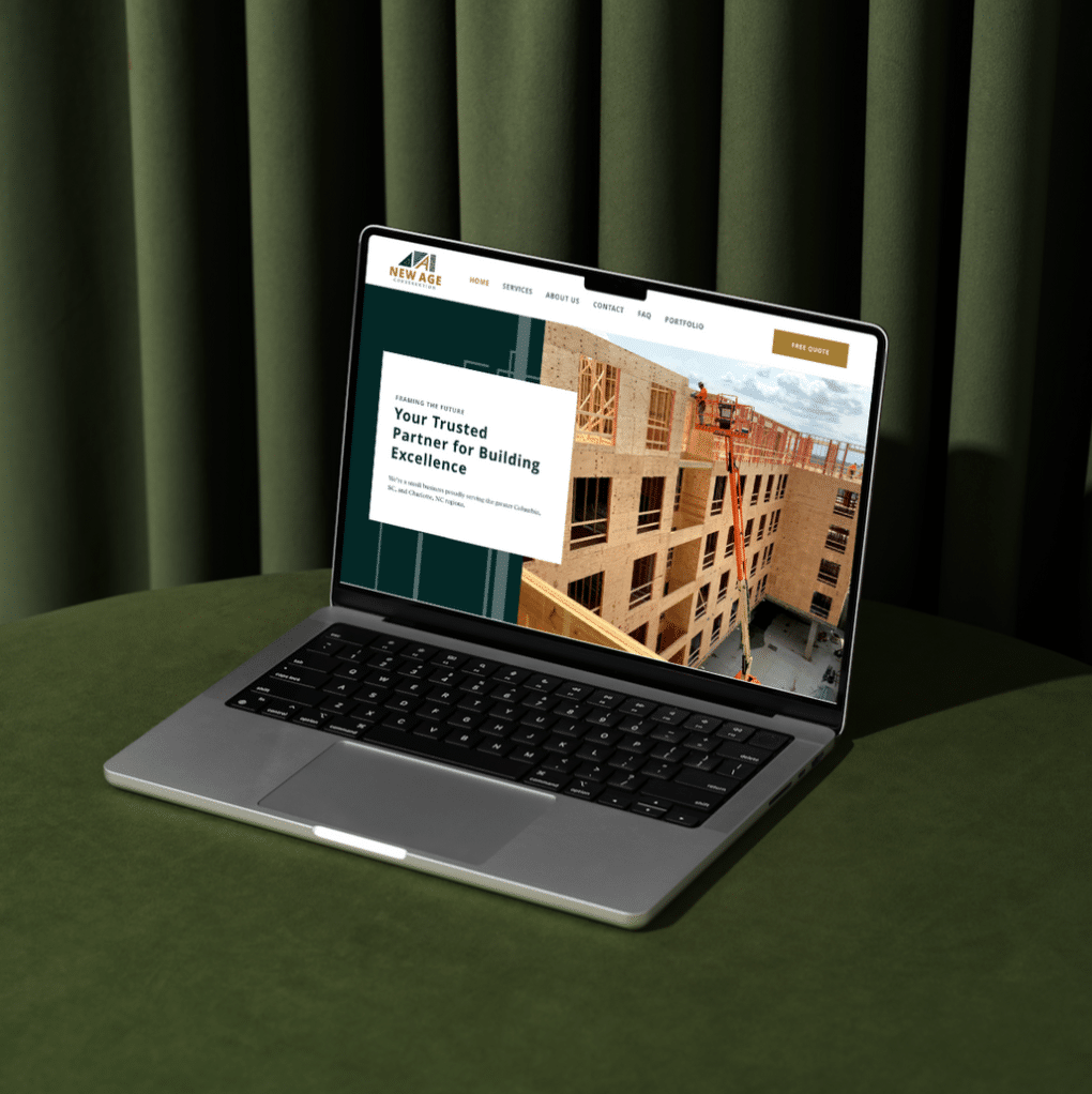 A laptop on a green table displays a construction company website with an image of a multi-story building under construction, showcasing their web design services. The text reads “Your Trusted Partner for Building Excellence.” Green curtains are in the background.