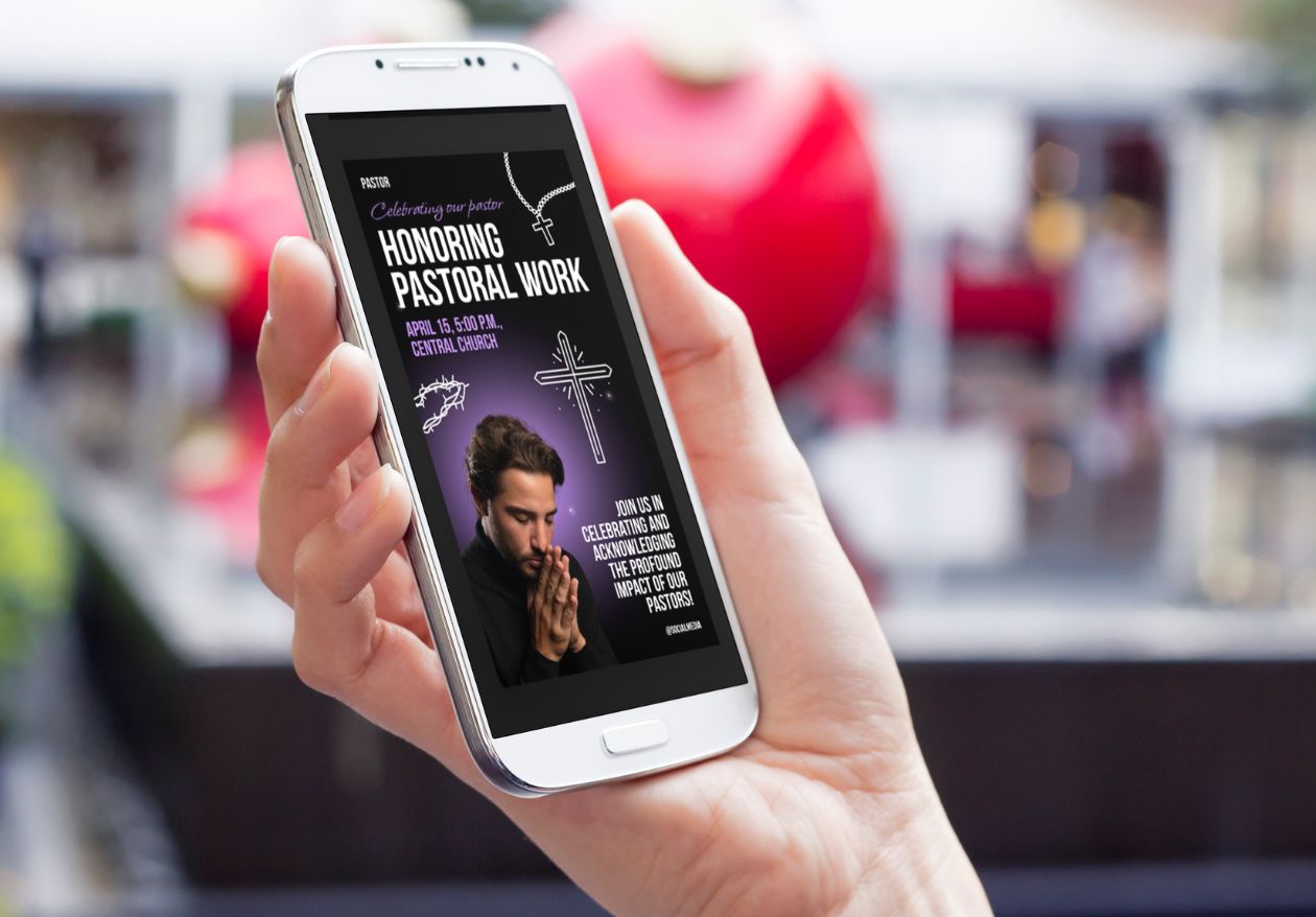 A hand holds a smartphone displaying an event flyer that reads, “Honoring Pastoral Work,” with a praying man, cross, and event details—showcasing the impact of custom website design by Moonlit Media. Blurred red and silver objects appear in the background.