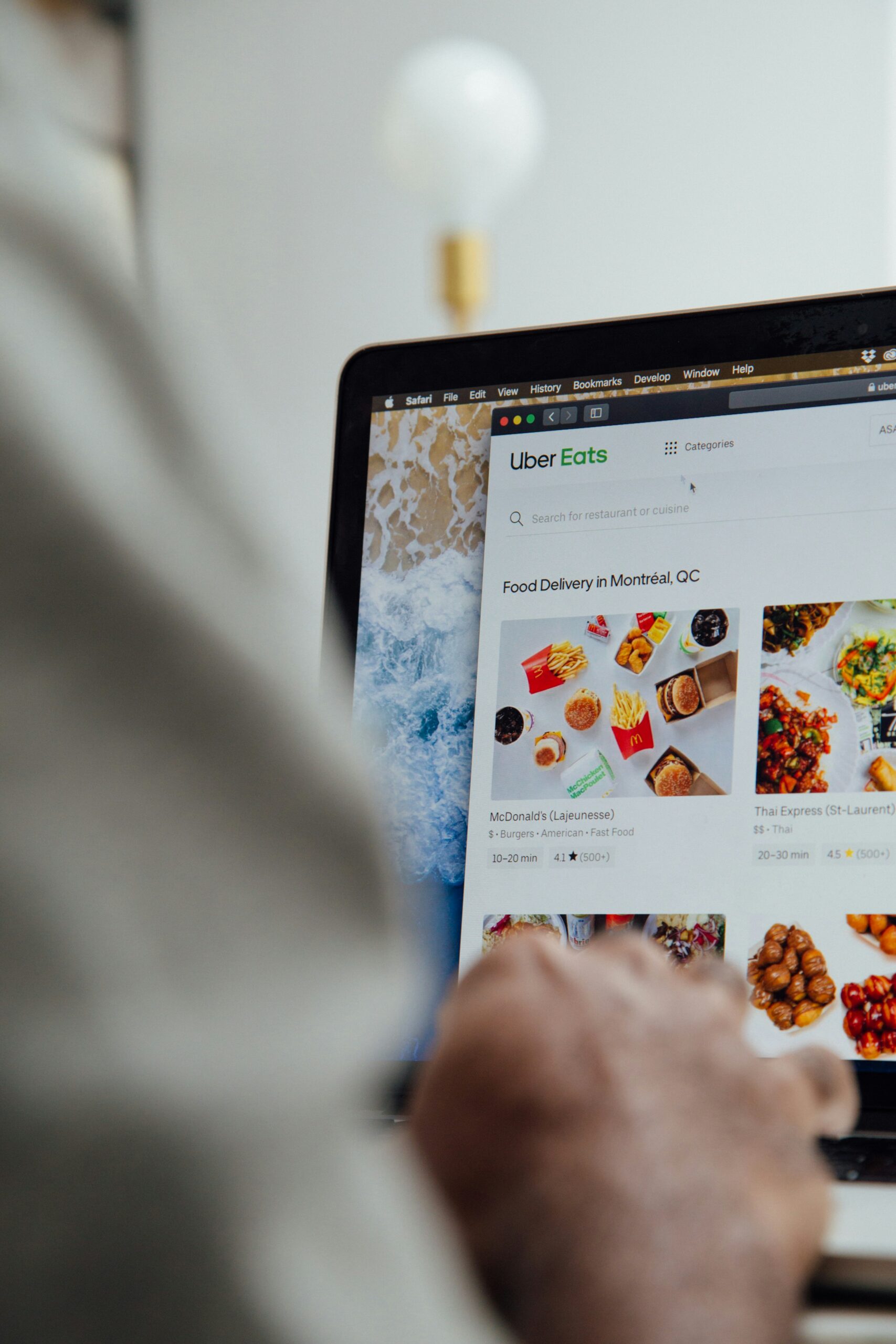A person browses the Uber Eats website on a laptop, searching for food delivery options, while admiring the site’s sleek layout crafted by a skilled web designer from Moonlit Media.
