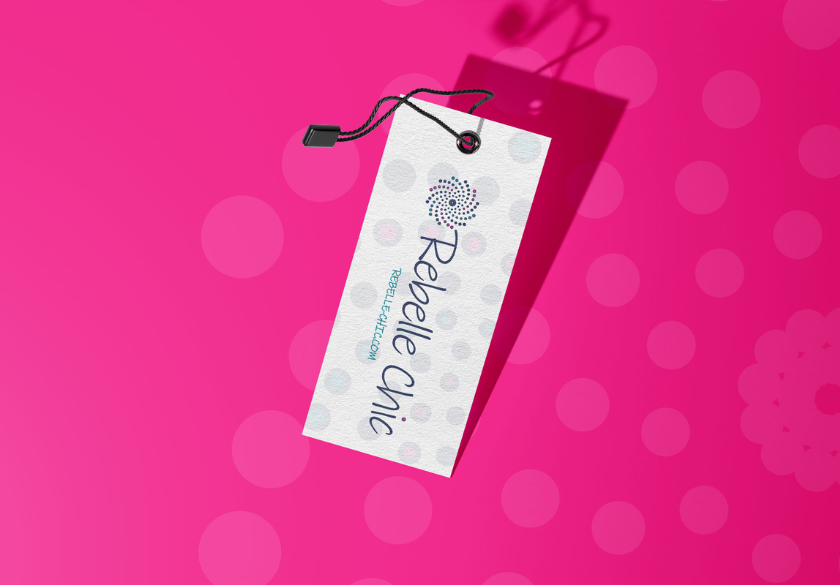 A rectangular white clothing tag reading Rebelle Chic with a spiral logo hangs by a black string against a vibrant pink background with lighter polka dots, subtly showcasing the hidden language of design communication.