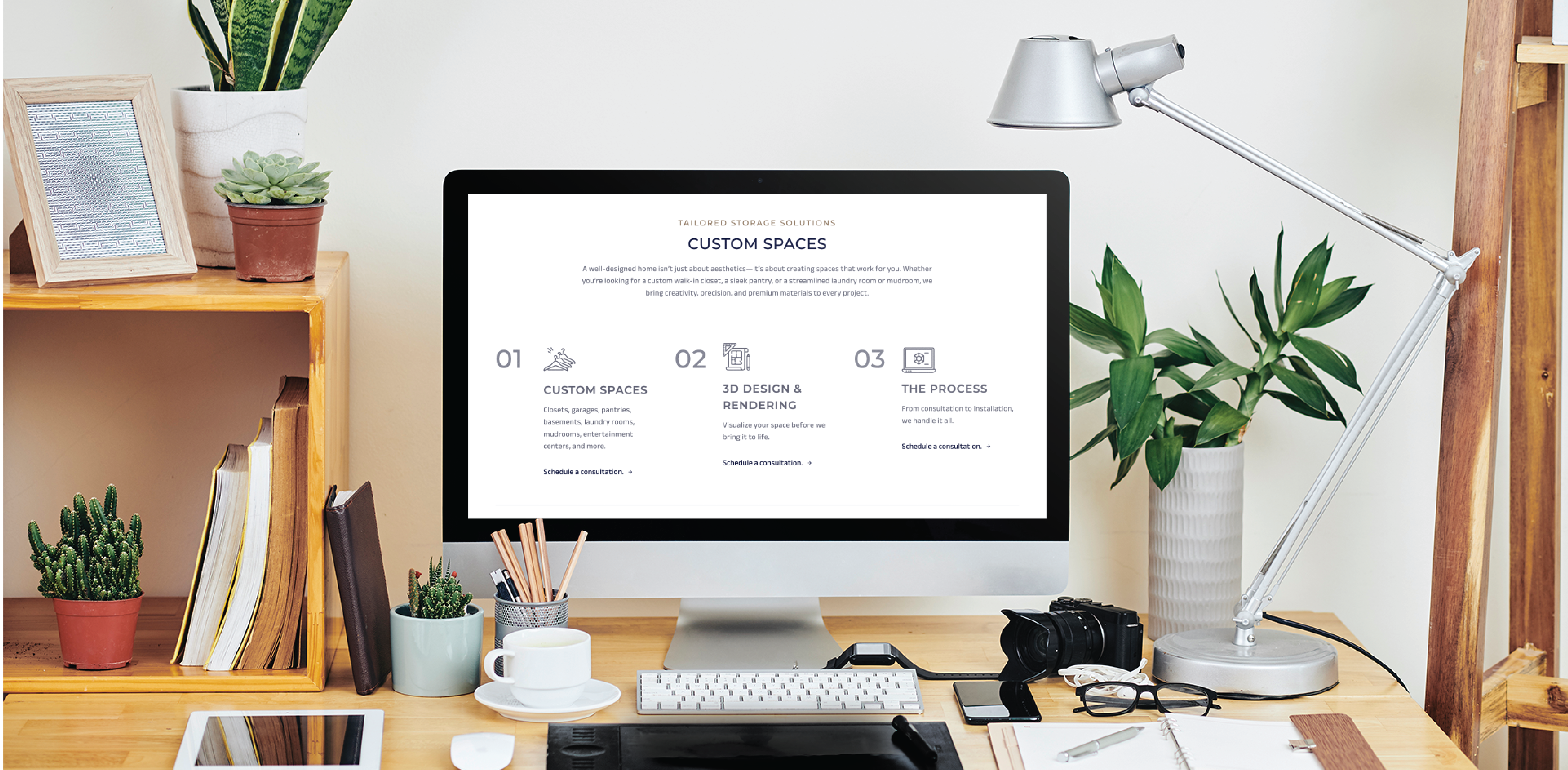 A desktop computer on a wooden desk displays a beauty salon web design. The desk holds notebooks, potted plants, a camera, mug, tablet, external hard drive, and silver lamp. Stylish shelves and decor complete the creative South Carolina workspace.