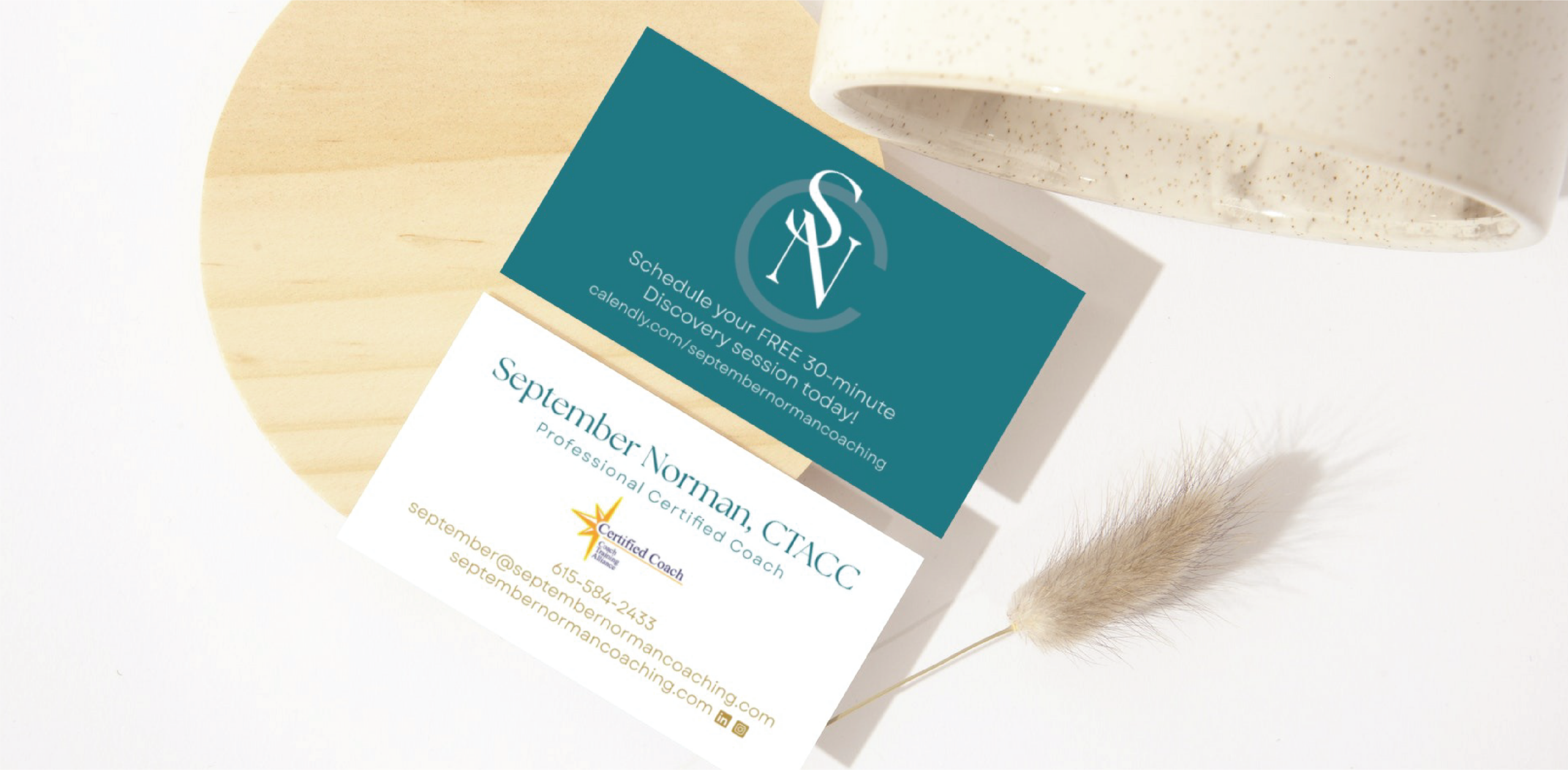 Two custom business cards on a light surface; one features a white SV logo on teal with contact info, the other highlights Tennessee life coach September Norman, CTACC, Professional Certified Coach, including contact details and a certification badge.
