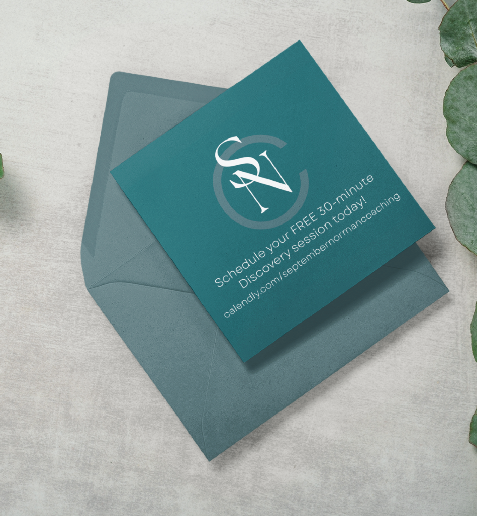 A teal Custom Business Card with white text about scheduling a free 30-minute discovery session for a Tennessee Life Coach rests on an open blue envelope. Green leaves decorate the top right and bottom right corners of the light-colored surface.