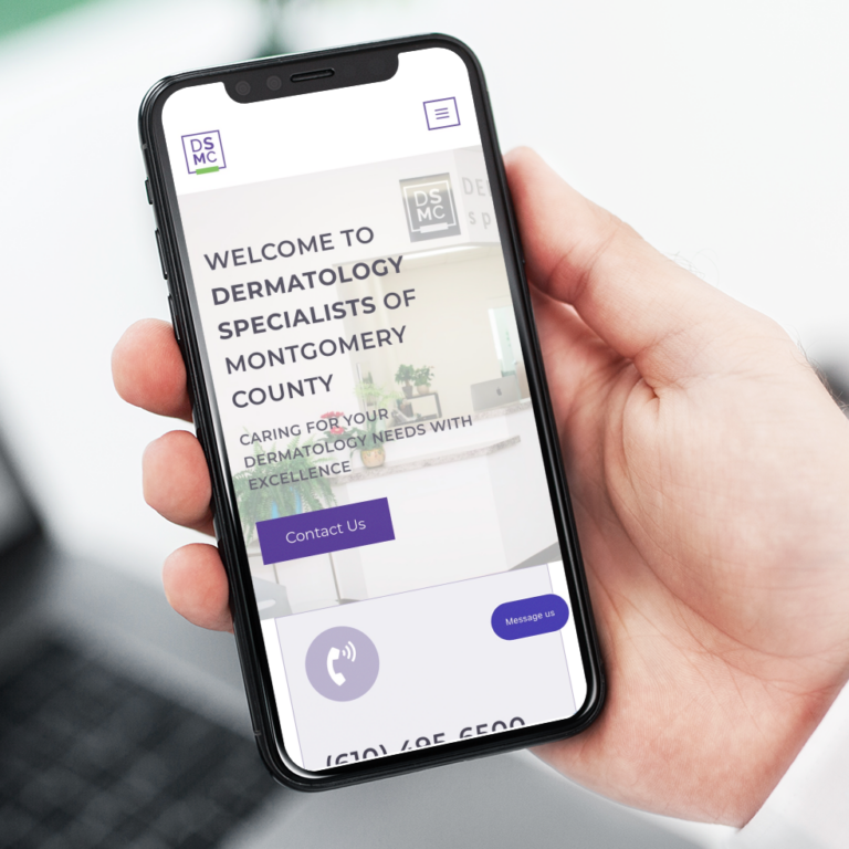 A person holds a smartphone displaying the Dermatology Specialists of Montgomery County website, showcasing the medical practice’s name, tagline, and contact options—highlighting modern website design in Pennsylvania.