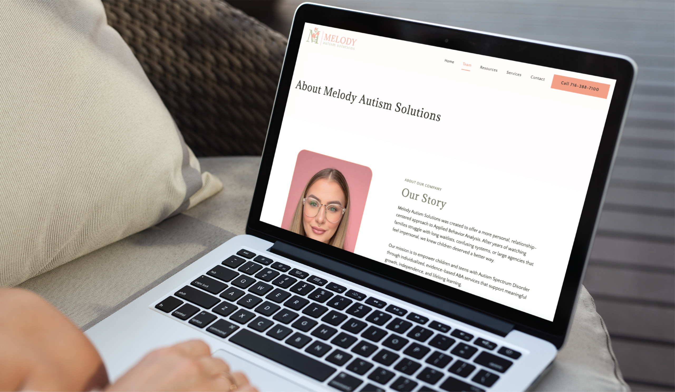 A person uses a laptop displaying the About Melody Autism Solutions webpage, featuring a profile photo of a woman, organization details, and navigation options—showcasing custom website design inspired by Philadelphia PA creativity.