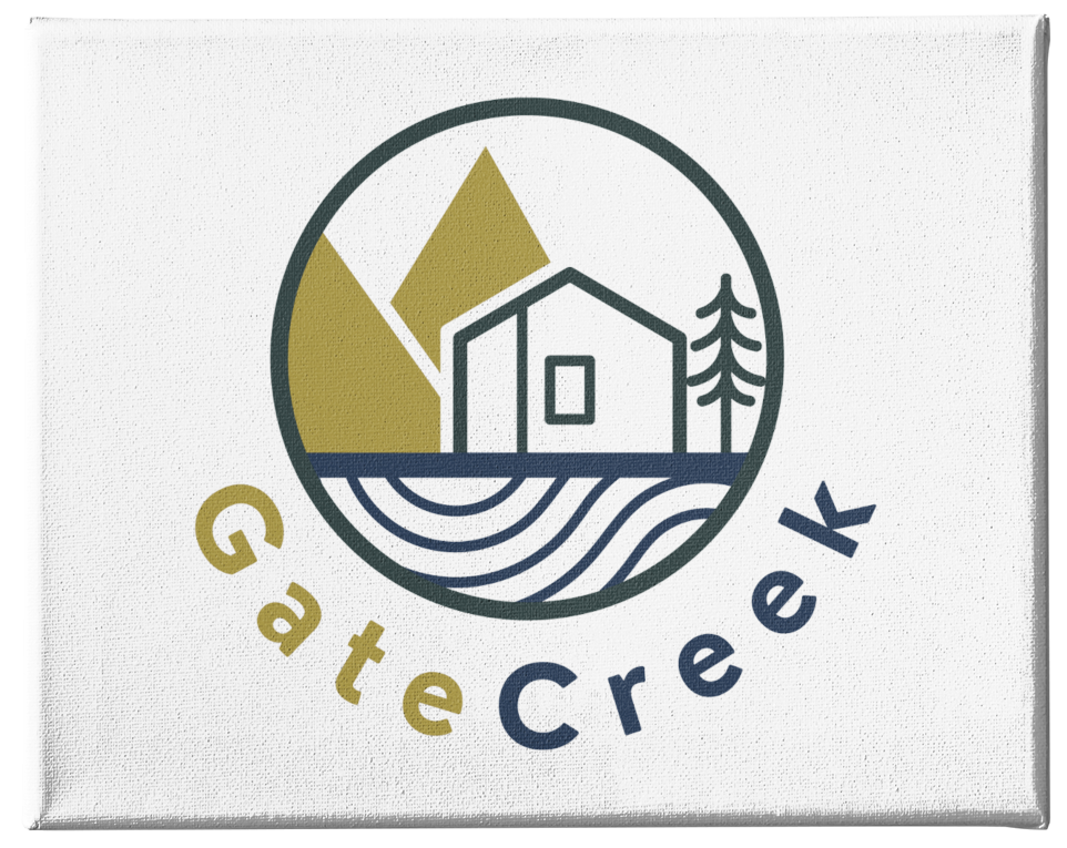 Logo for US-based, women-focused business “GateCreek” featuring a simple house, tree, and mountains in a circular frame above stylized water lines. The text “GateCreek” curves below, with “Gate” in olive green and “Creek” in navy blue.