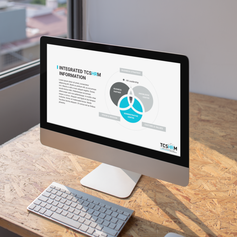 A desktop computer on a wooden desk displays a presentation slide about integrated TCSHRM information, featuring a circular diagram with business partners, organizational environment, and administrative experts—perfect for Minnesota HR Management professionals.