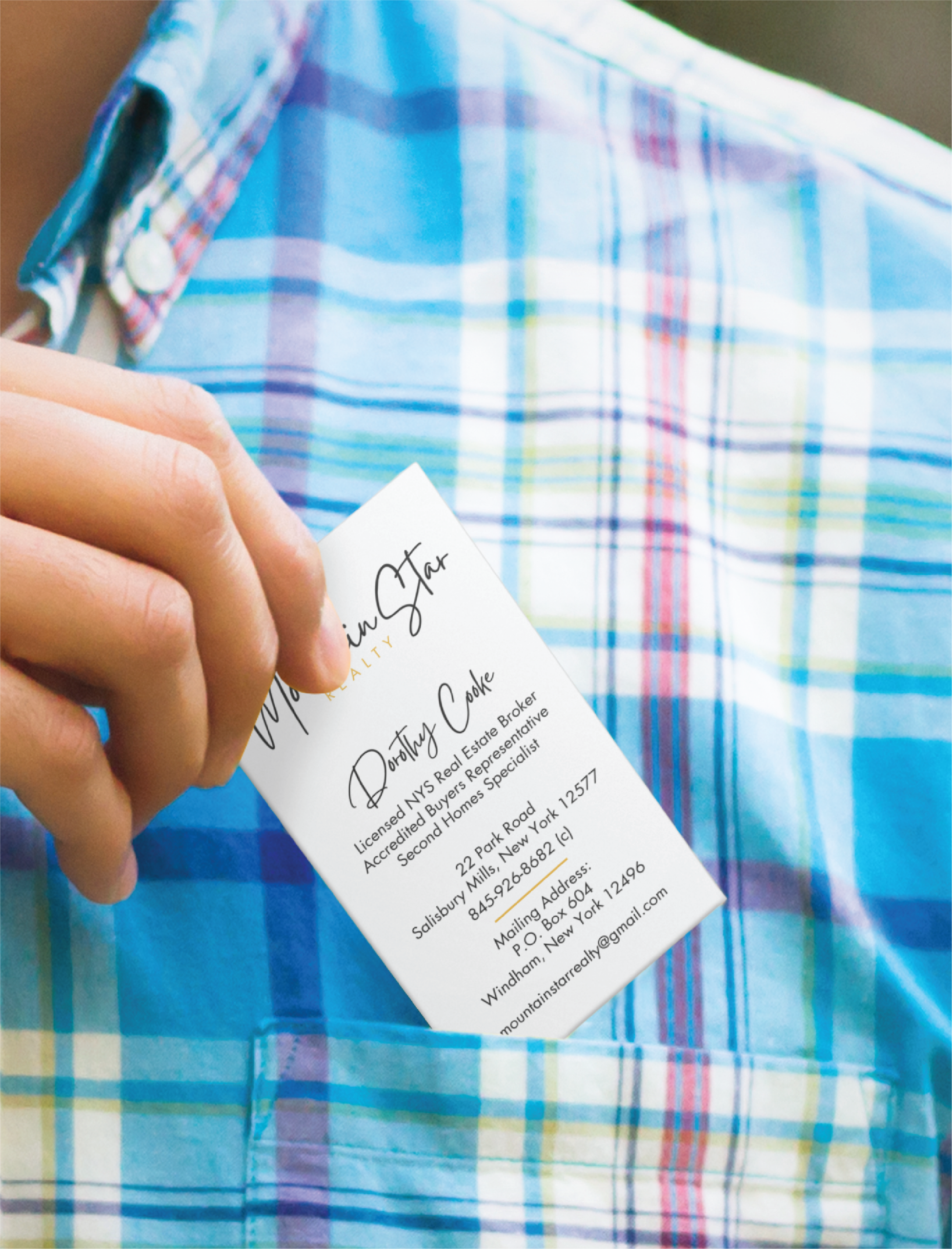 professional graphic design for businesses | Moonlit Media LLC A person in a blue and green plaid shirt is placing a business card, featuring sleek stationery design, into their chest pocket. The card has text and a logo, suggesting it may belong to a general contractor in Michigan.