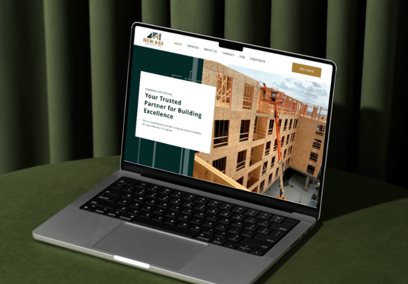 A laptop on a green surface displays a construction company’s small business website design with a photo of a wooden building under construction and the text, Your Trusted Partner for Building Excellence. Green curtains are in the background.