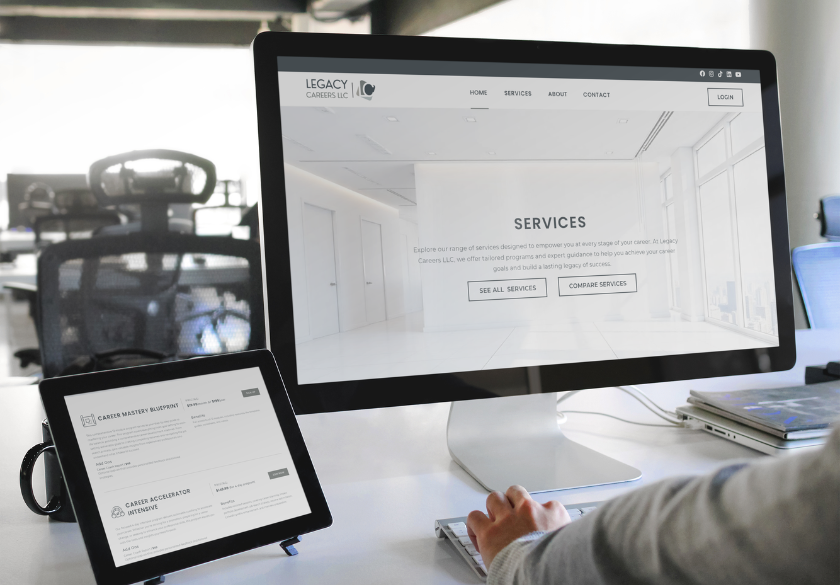 A person uses a desktop computer displaying the Services page of Legacy Careers LLC, known for Small Business Website Design that Ages Well, in a modern office; a tablet nearby shows a related career assessment program.