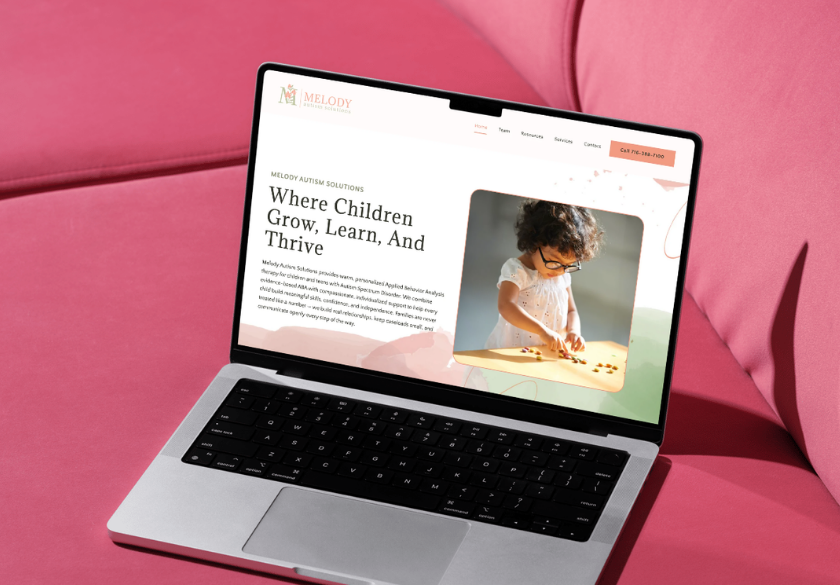 A laptop on a pink couch displays a website called “Melody Autism Solutions,” featuring a headline about children growing and thriving, reassuring parents with a photo of a young girl engaged in ABA Therapy using a wooden toy.