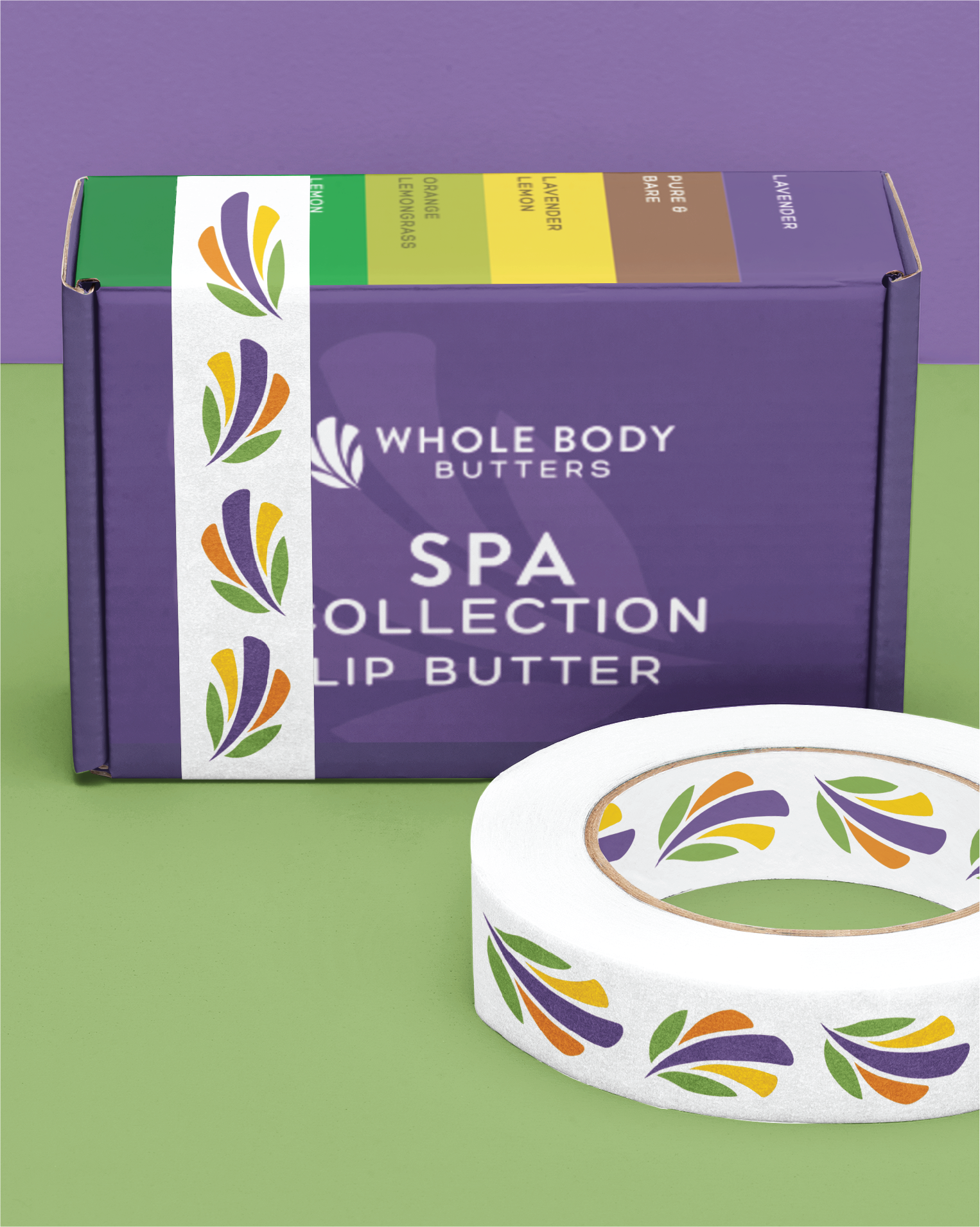A purple Whole Body Butters Spa Collection Lip Butter box sits on a green surface with a roll of decorative tape in front, featuring a colorful leaf pattern inspired by Colorado’s vibrant nature and creative stationery design.