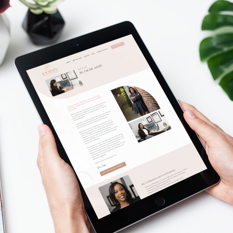 A person holds a tablet displaying a website for Dr. Sade, highlighting her professional credentials and counseling services in Virginia. A plant and part of a coffee cup are visible in the background, emphasizing the site's modern website design.
