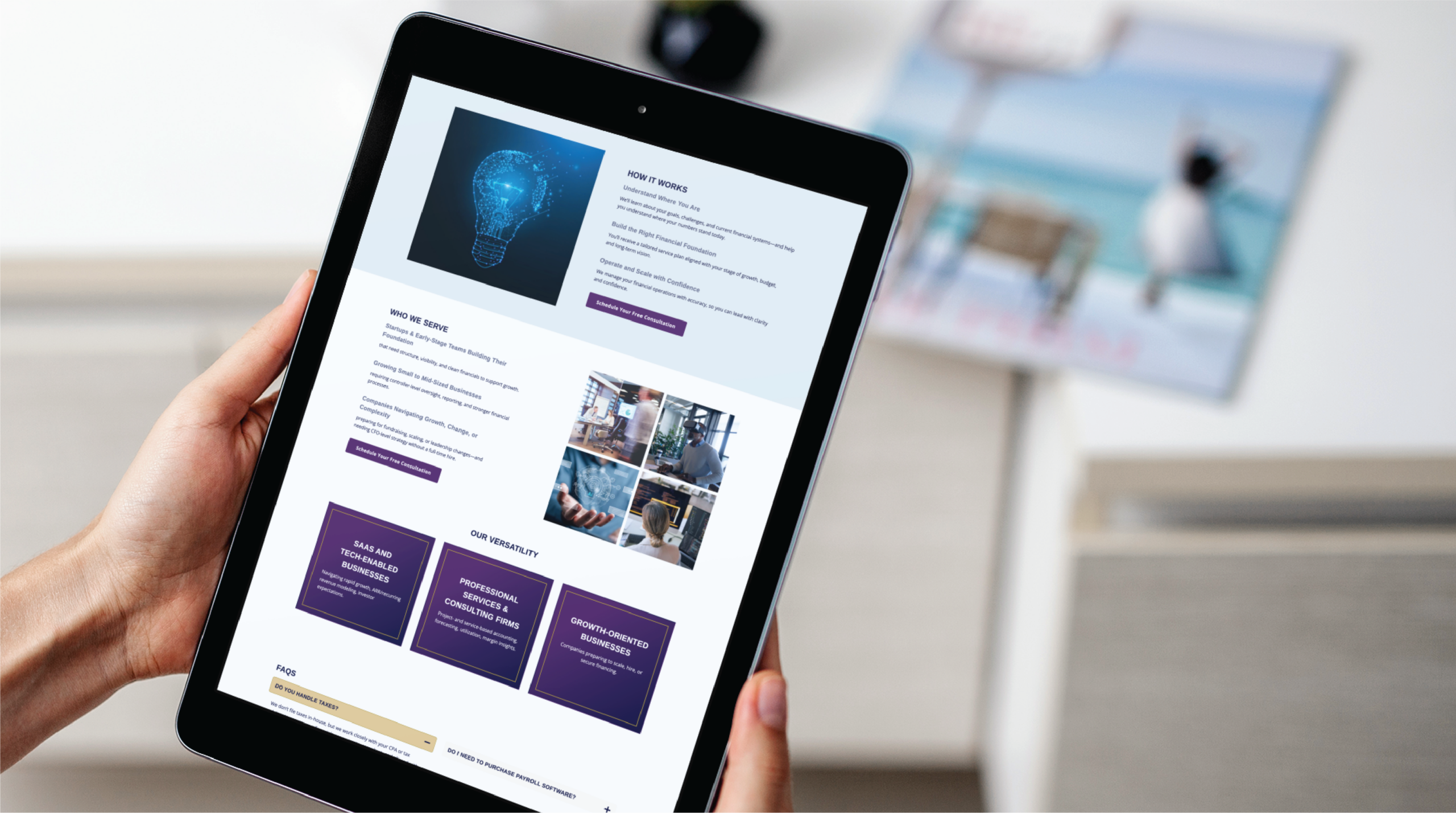 A person holds a tablet displaying a Texas website design with images, text, and purple highlights; a blurred magazine with a beach scene lies in the background on a white table.