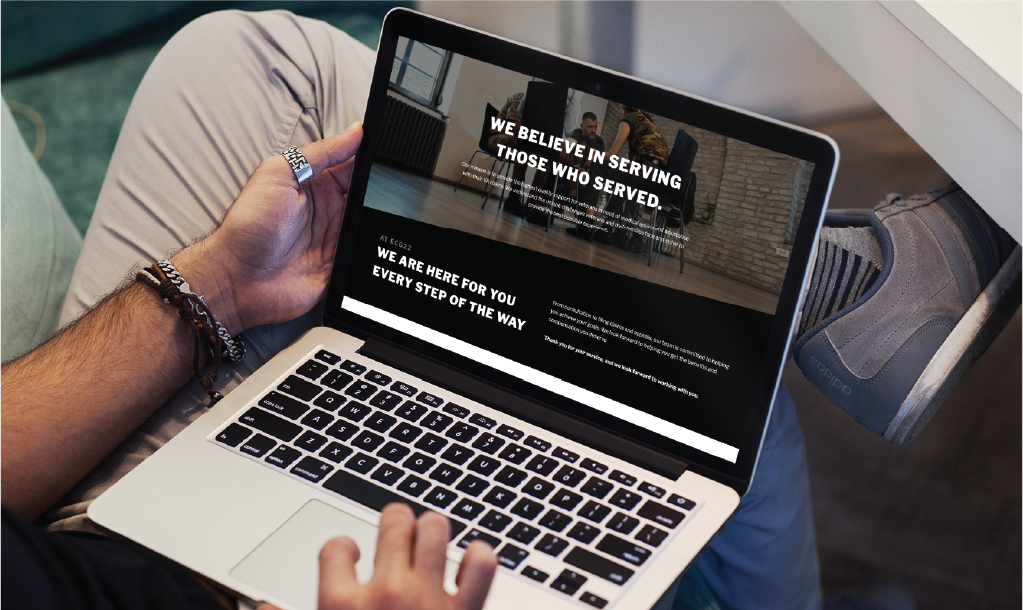 A person sits on a couch using a laptop. The laptop screen displays a custom website design for counseling services in Texas, featuring the message We believe in serving those who served and We are here for you every step of the way.