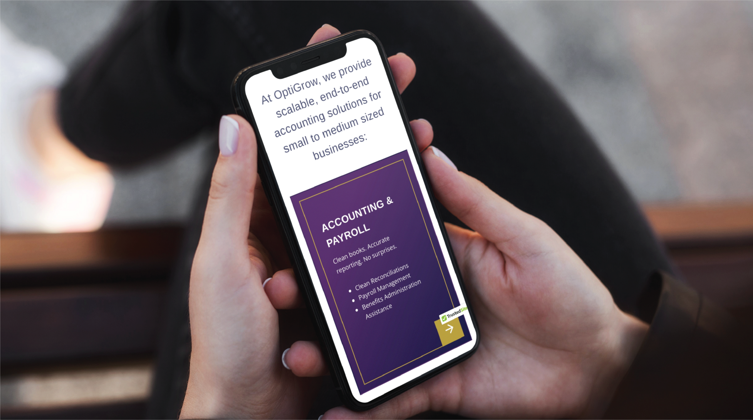 A person holds a smartphone displaying a website about scalable accounting and payroll solutions for small to medium businesses in Texas, featuring a purple section with service details.