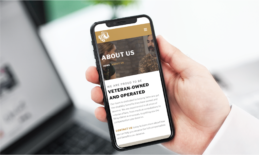 A hand holds a smartphone displaying an About Us page, highlighting the Texas-based, veteran-owned company and showing part of the text and images of two people. The site showcases their expertise in custom website design.