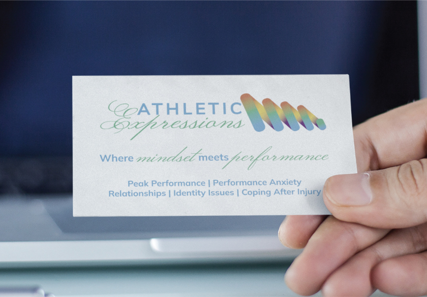 A hand holds a business card for Athletic Expressions, a company focused on mindset and performance. Showcasing effective print marketing for local businesses, the card lists services: peak performance, performance anxiety, relationships, identity issues, and coping after injury.