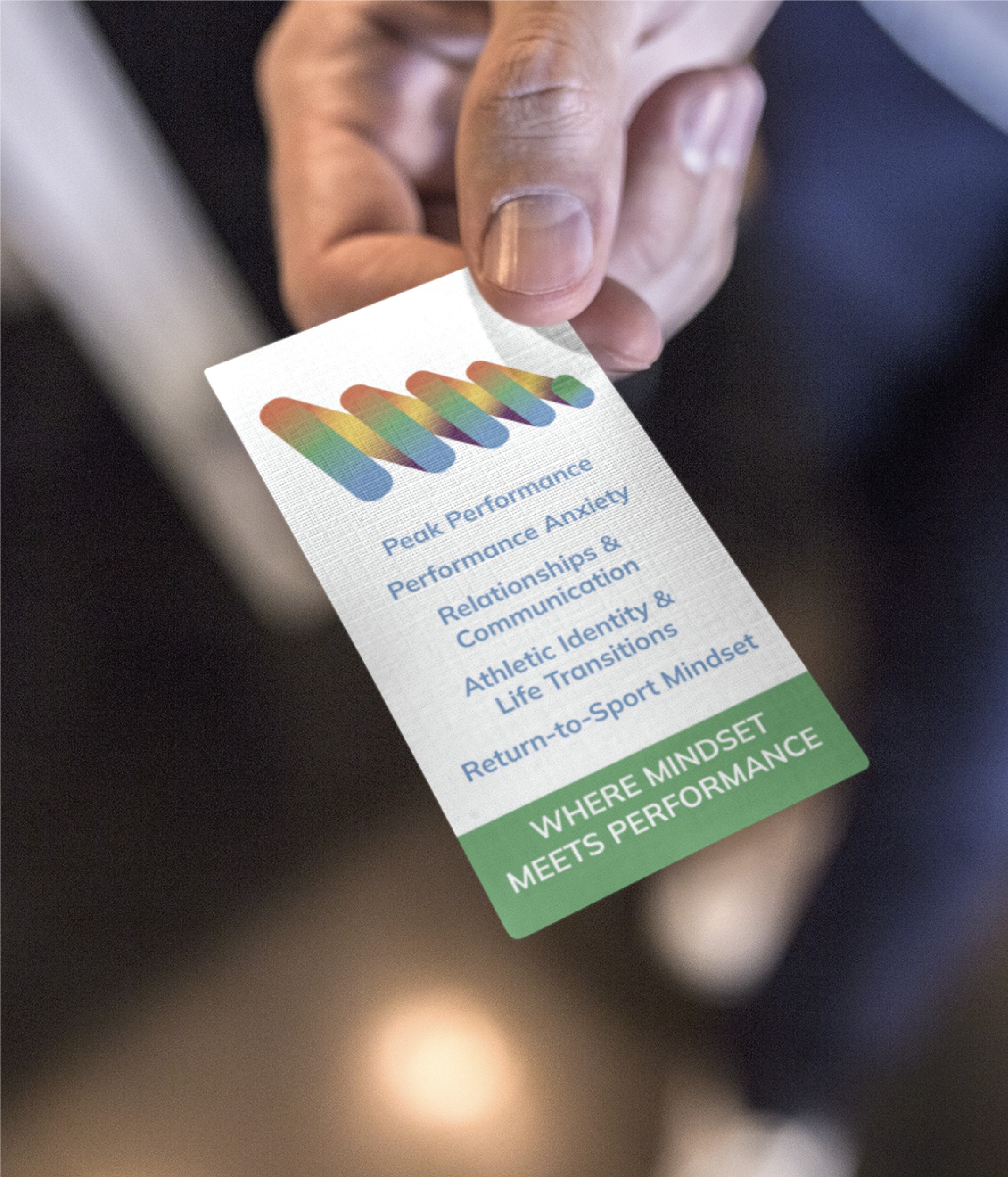 A hand holds a professionally crafted business card listing services like peak performance, anxiety, relationships, communication, athletic identity, life transitions, and return-to-sport mindset. With its sleek Michigan-inspired business card design and the tagline "Where mindset meets performance," this business service stands out for those seeking personal growth and excellence.