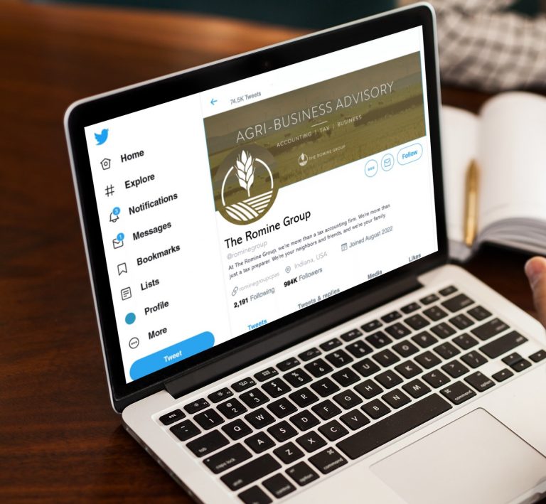 Laptop screen showing a Twitter profile for The Romine Group with left navigation menu and cover image.