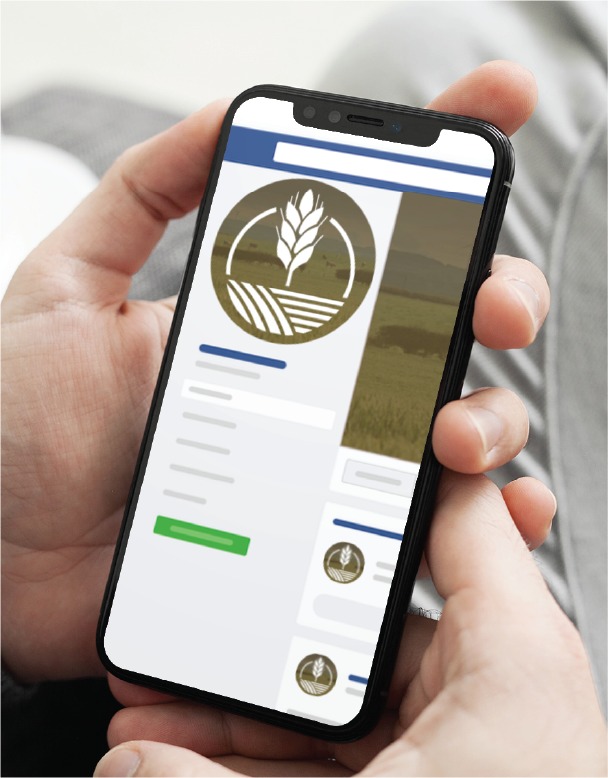 Person holds a smartphone displaying an agricultural app with a circular logo and a list layout on screen.