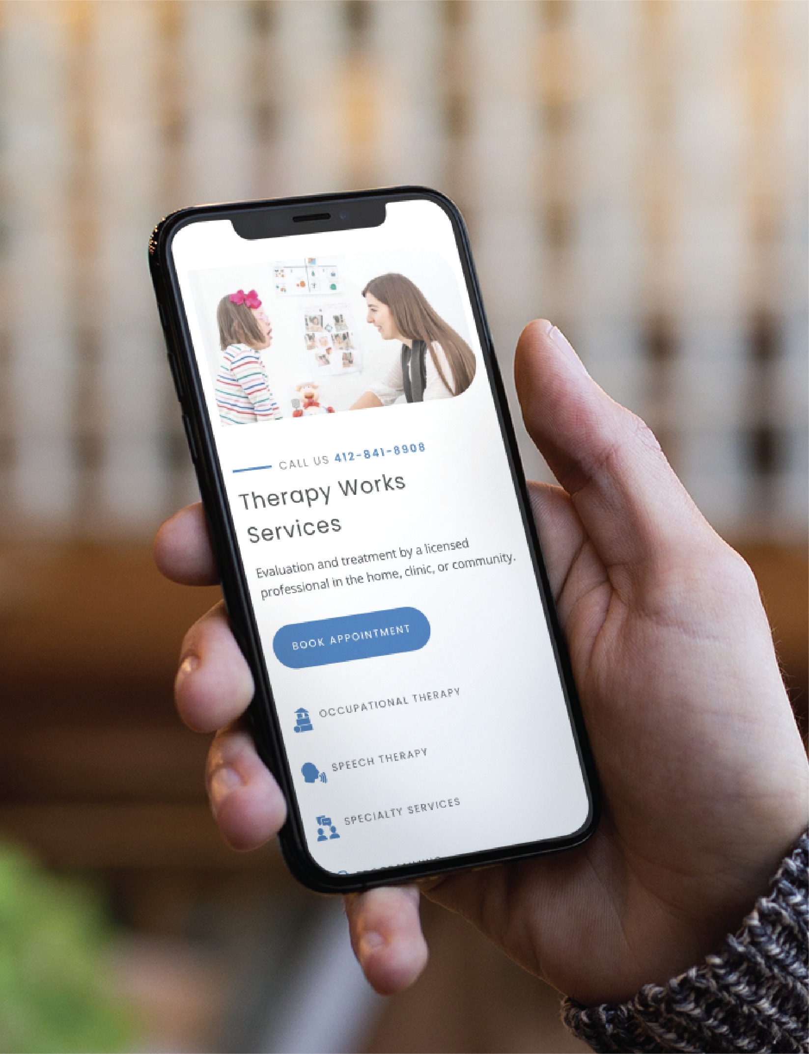 A hand holds a smartphone displaying a Youth Therapy services website, showcasing a therapist and child in session, contact info, and options for occupational, speech, and specialty therapy available throughout Pennsylvania.