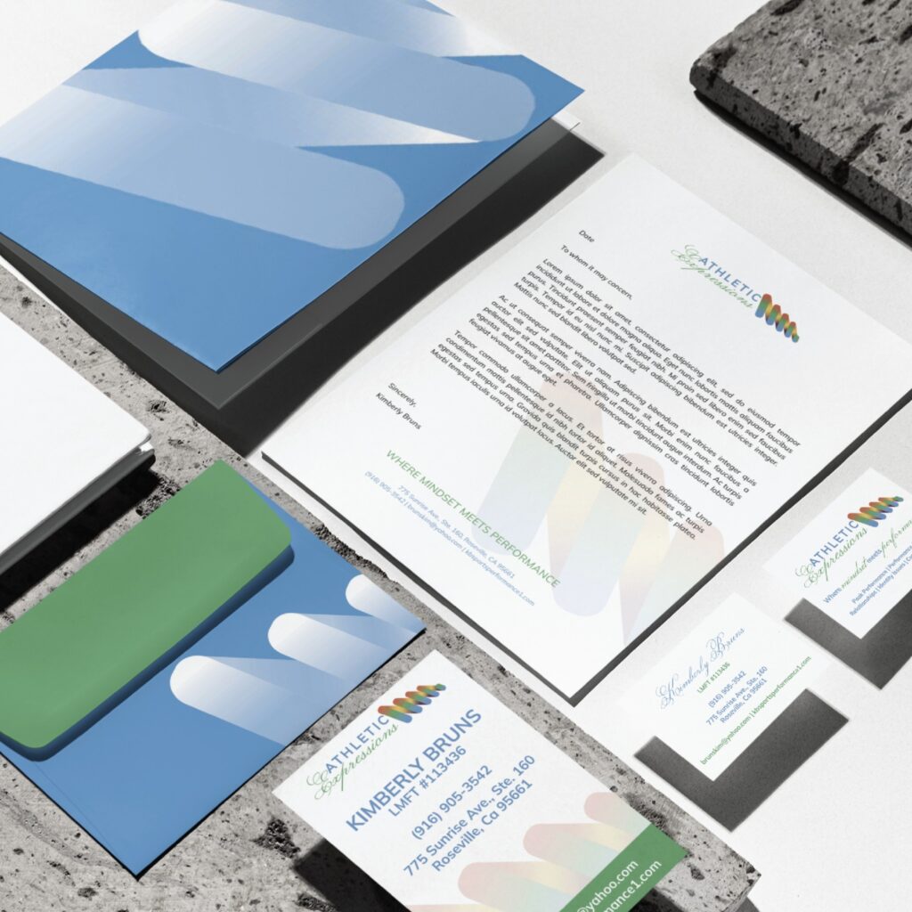 A stationery set with blue and green accents includes letterheads, envelopes, business cards, and folders, all featuring a modern logo with overlapping shapes inspired by Sports Performance Coaching in California. This striking stationery design is arranged neatly on a stone-like surface.