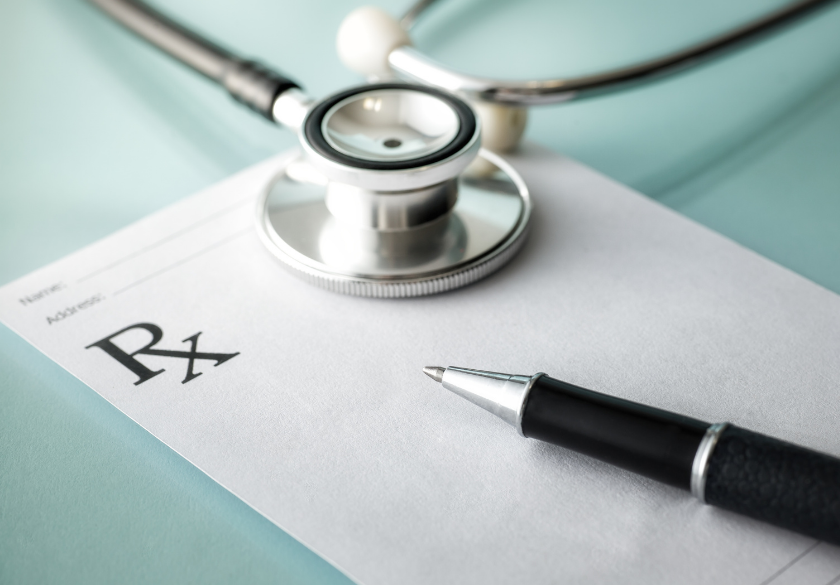 A stethoscope and pen resting on a blank prescription pad with an Rx symbol, suggesting a medical setting or a doctor’s office—perfect imagery for when you build a new patient page for your medical practice website.