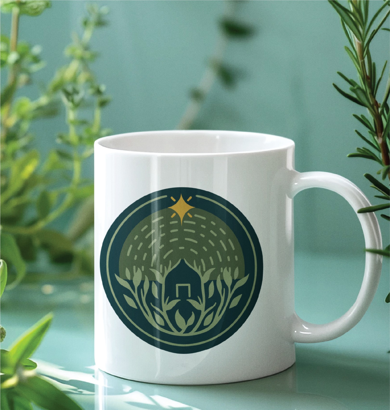 White mug with a green and gold circular logo illustration featuring a stylized hive, bees, and plants—perfect for anyone passionate about garden care—set against a background of blurred green foliage and a blue-green surface reminiscent of sunny California mornings.