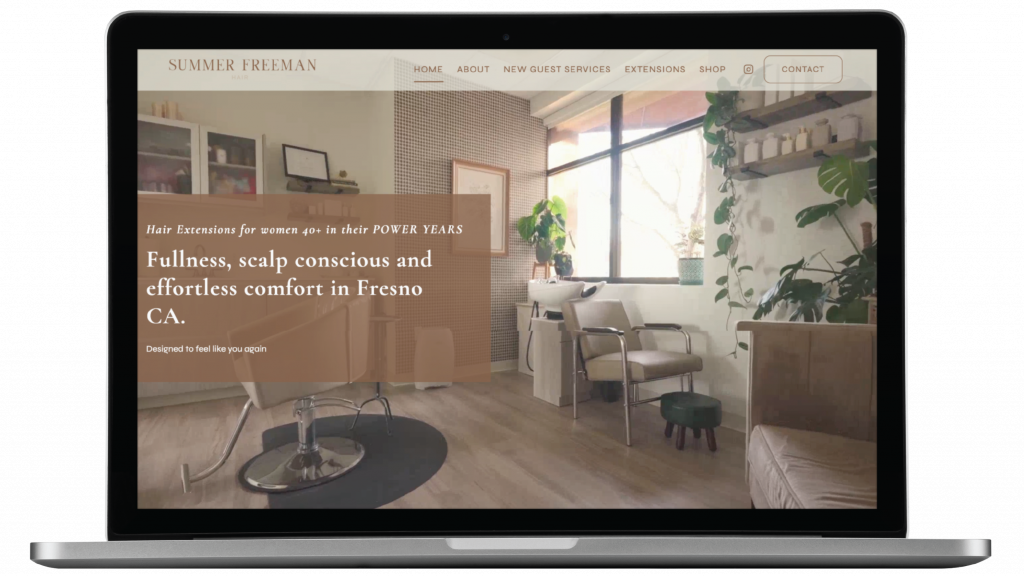 A laptop displays a beautifully crafted website design for a hairdresser in California, featuring a cozy, modern salon interior photo. The site promotes hair extensions for women in their power years in Fresno, CA, with warm wooden accents and lush green decor visible.