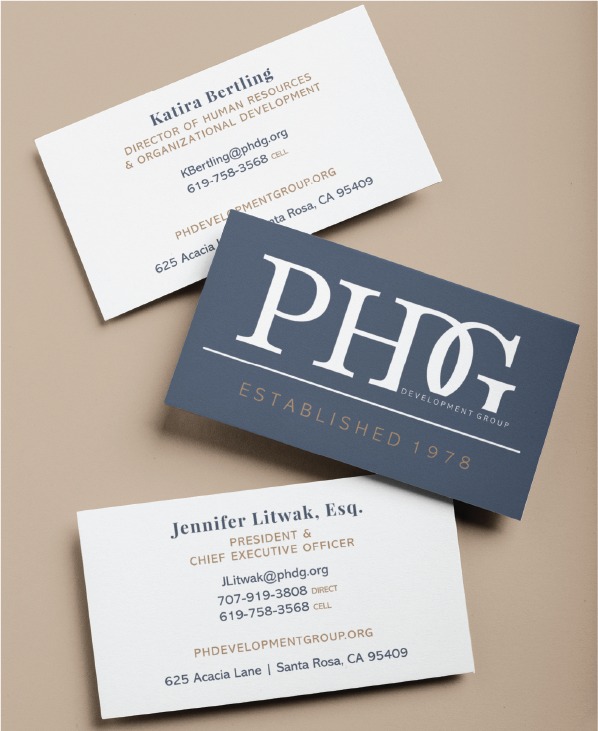 Set of three business cards featuring the PHG Development Group logo on a blue card and contact details on white cards.