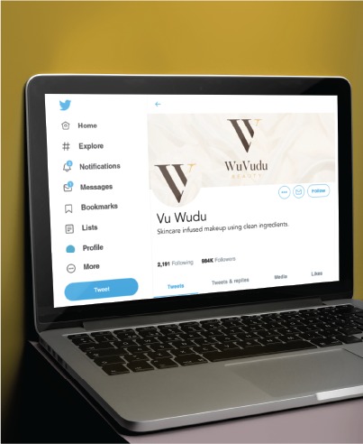 A laptop displays a Twitter profile for Vu Wudu, a skincare-infused makeup brand based in Indiana, featuring Social Media Design elements, with 884K followers and a beige logo on the screen.