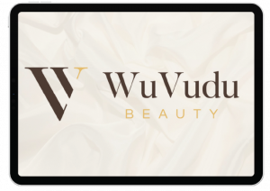 Tablet screen displaying the WuVudu Beauty logo with stylized W and gold accents on a soft, white fabric background—perfect inspiration for your next Social Media Design project in Indiana.