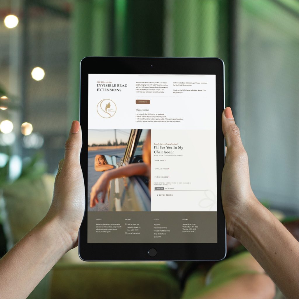 A person holds a black tablet displaying a website about invisible bead extensions. The website, featuring sleek California-inspired website design, highlights an image of a woman leaning out of a car window and text with appointment and service details for hairdresser services.