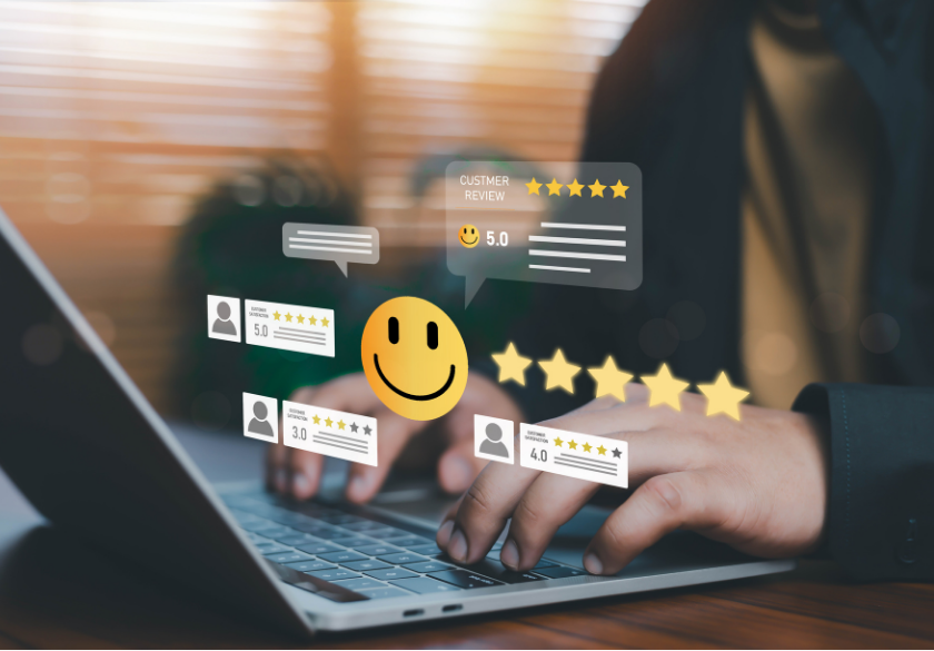 Hands typing on a laptop with digital graphics of customer reviews, star ratings, and a large smiley face overlaid, symbolizing positive online feedback, high satisfaction, and strong website trust.
